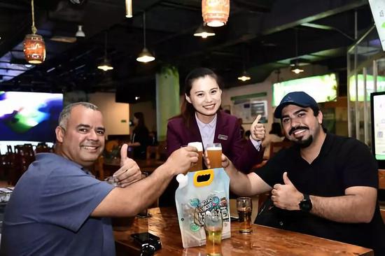 2018年5月17日拍摄的在青岛啤酒博物馆，外国游客举起青岛啤酒干杯。新华社记者郭绪雷摄