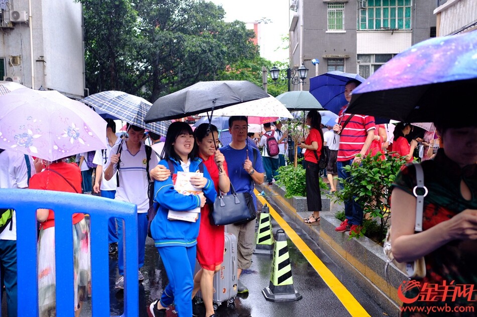 广州高考生雨中赶考 家长穿红衣旗袍送考