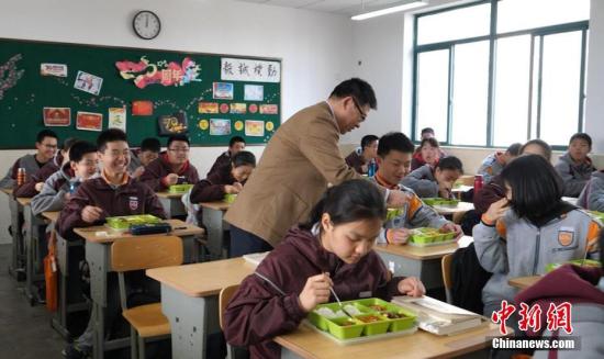 资料图：校长走进教室与学生一起吃中饭。葛勇 摄