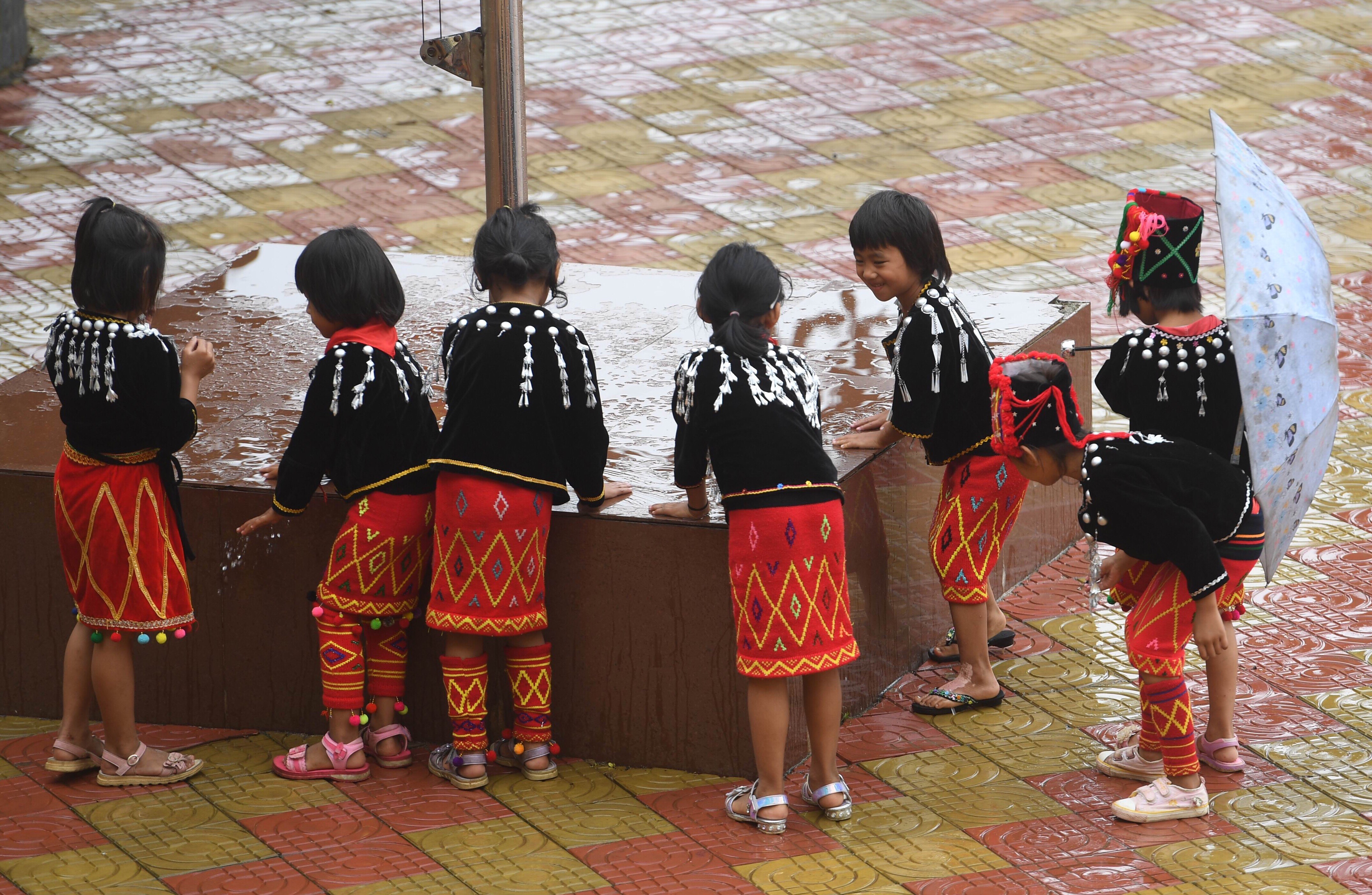 6月21日,在芒市西山乡营盘民族小学,景颇族学生在操场上玩耍.